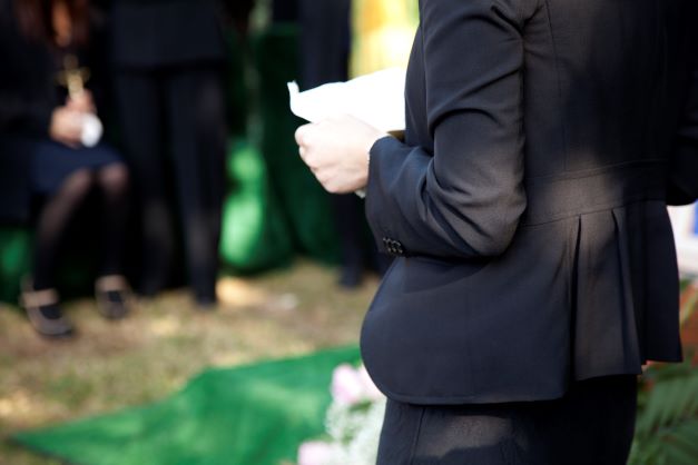 Person speaking at a funeral.
